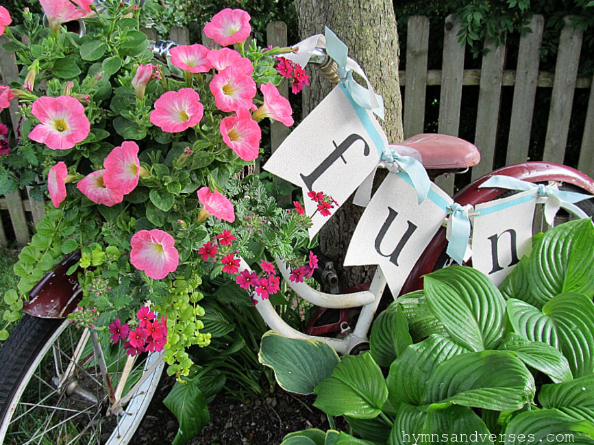 vintage bicycle with basket planted with wave petunias and verbena