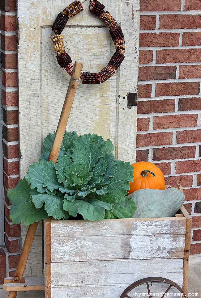 Primitive Wood Wagon with Ornamental Cabbage and Pumpkins for Fall with Indian Corn Wreath on Old Shutter.