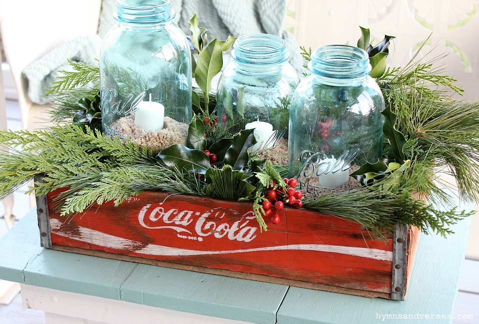 Vintage coke crate with blue ball jars and candles.