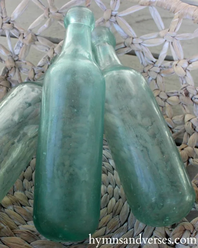 Wall art: old window frame, chicken wire, old bottles and greenery