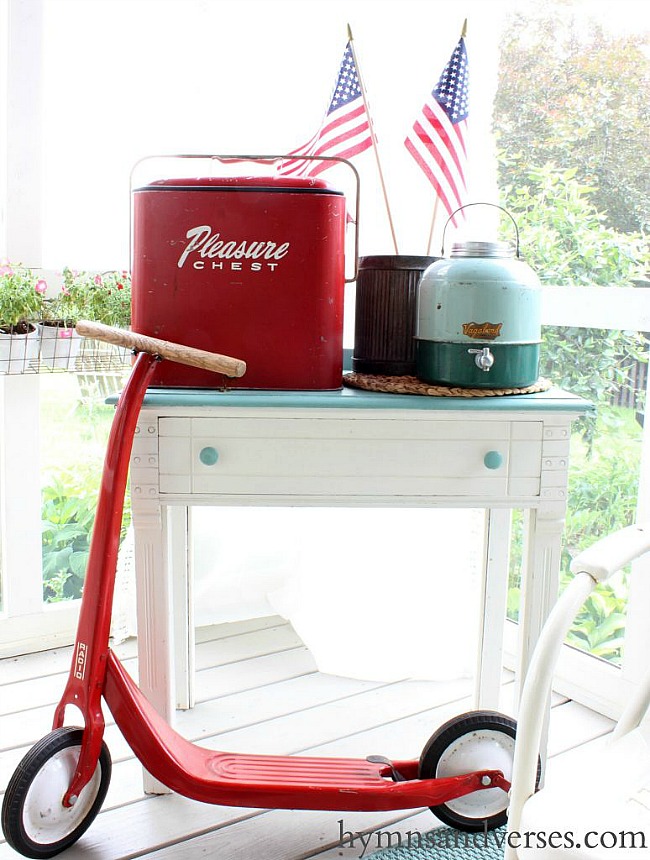 Vintage red scooter, ice chest, and vintage cooler. Vintage Americana Screen Porch