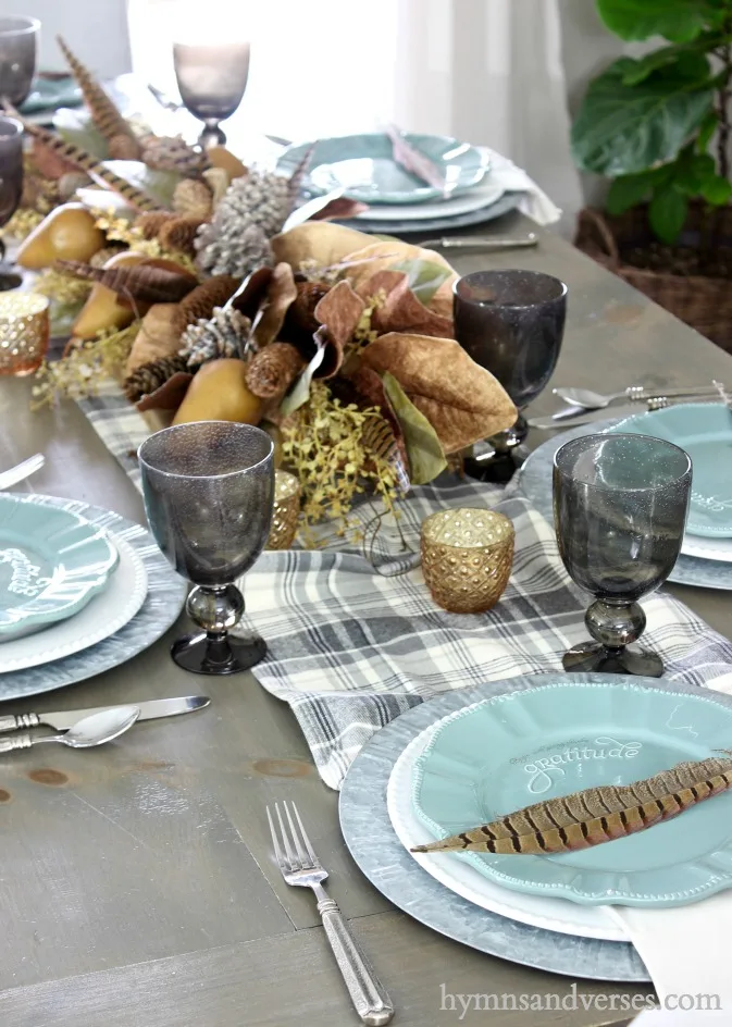 Thanksgiving table with Plaid runner and place setting with pheasant feathers