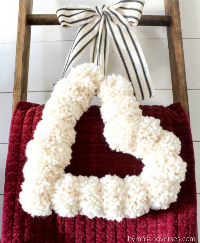 Pom Pom Heart Wreath Hanging from Blanket Ladder with Striped Ribbon