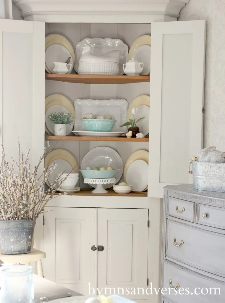 Aqua, yellow, and white decor in corner cabinet