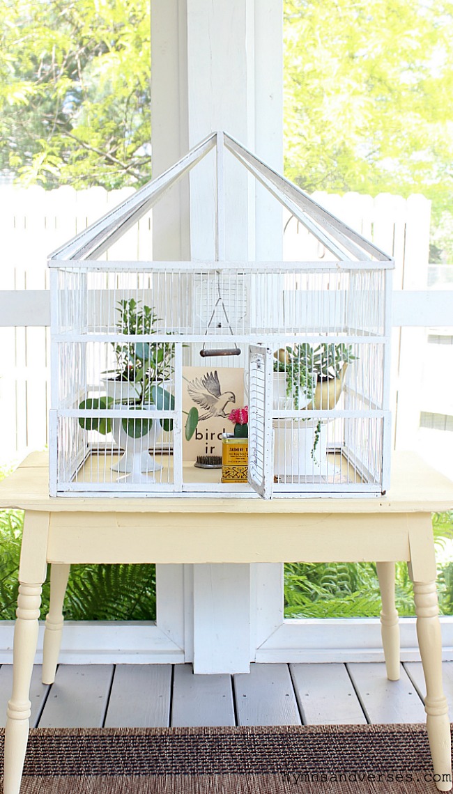 White vintage bird cage on yellow table