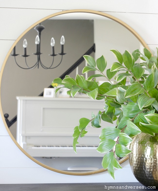 Round Brass Mirror Reflection of Piano