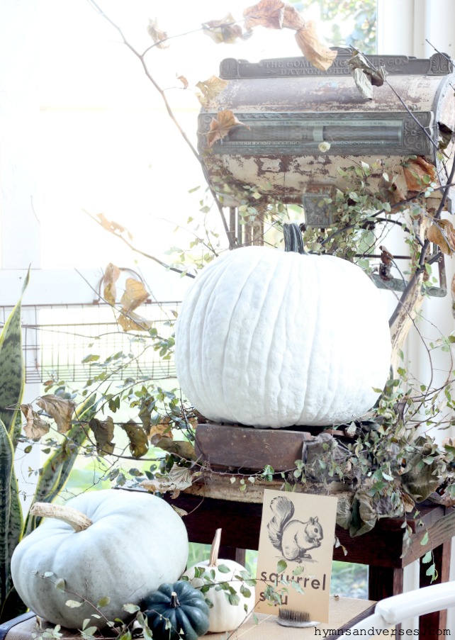 Large antique scale styled for fall with pumpkins and branches