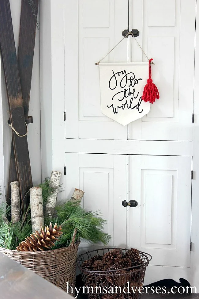 Vintage Corner Cabinet at Christmastime with vintage skis and Joy to the World Banner.