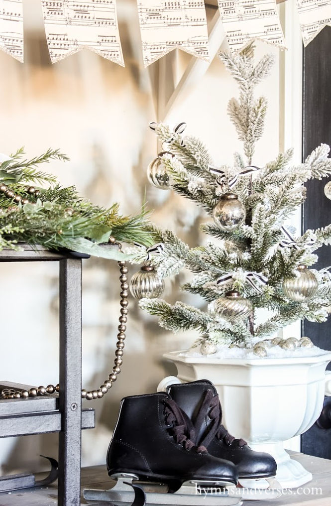 Small flocked Christmas tree in ironstone soup tureen with vintage black child's skates.