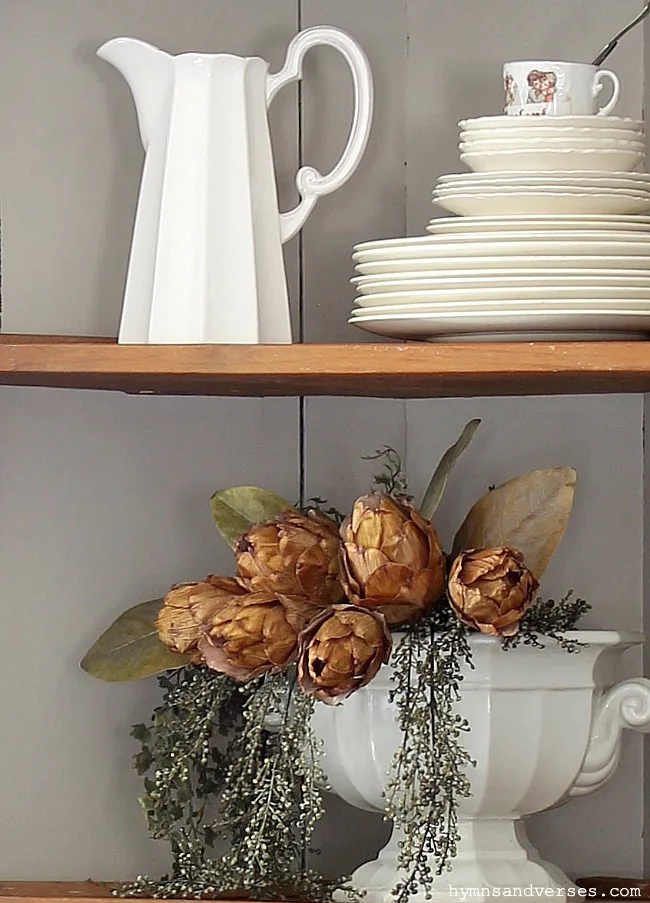 Antique corner cabinet shelves styled with vintage ironstone.