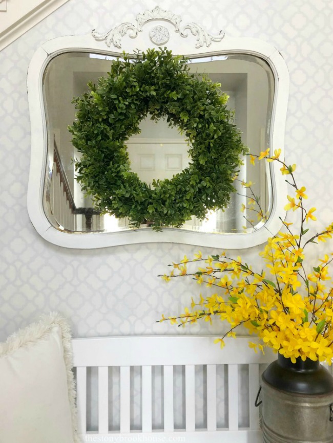 Entryway with stenciled wall white mirror and forsythias
