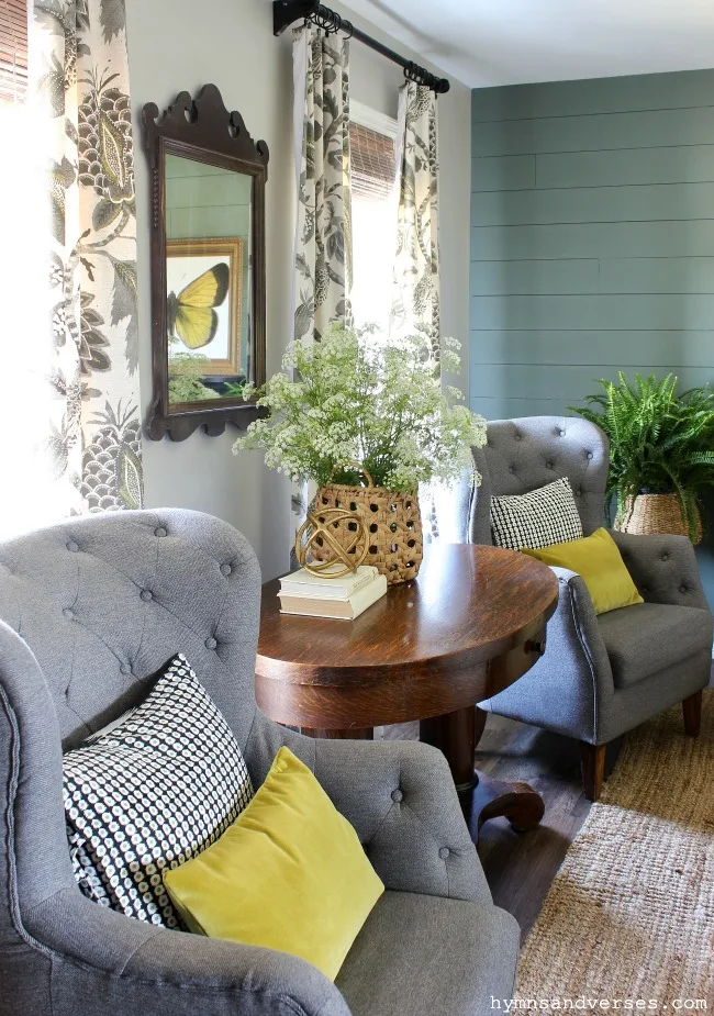 Living room with gray tufted chairs and vintage library table and basket of Queen Anne's Lace and vintage Chippendale mirror - Hymns and Verses Blog